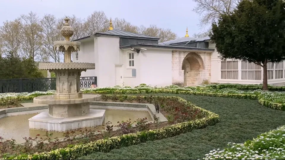 Benches and domed palace buildings in a manicured courtyard